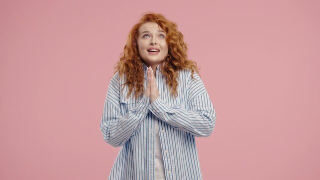 Young pretty woman praying with palms in sincere silent request. Hope, faith