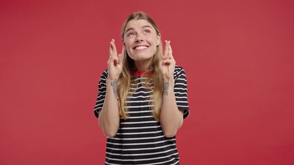 Young pretty woman praying with crossed fingers in sincere request. Hope, faith