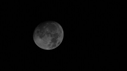Earth’s Moon (Luna) captured in the night sky. A detailed monochrome view of lunar surface with visible craters and textures, symbolizing mystery and cosmic beauty