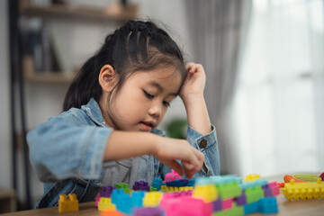 Young Girl Engaged in Colorful Construction Play with Building Blocks in a Bright and Cozy Indoor Setting, Focused and Creative Learning Experience