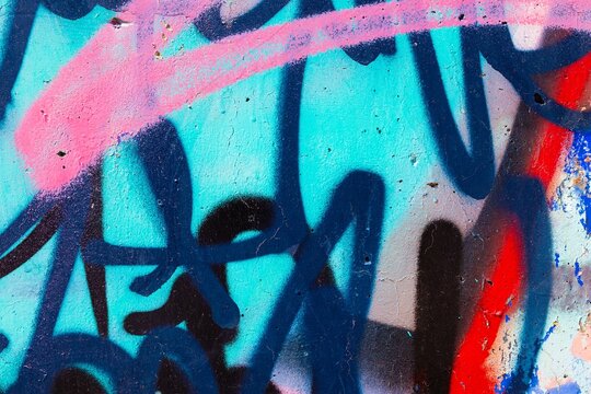 Fototapeta Vibrant graffiti art in neon blue, pink, red. Modern 2000s street style, bold colorful strokes, urban vibe. Posters, digital art, creative banner, Y2K inspired visuals.