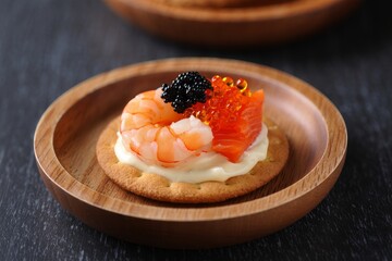 Elegant Appetizer with Shrimp, Salmon, and Caviar on Rye Cracker