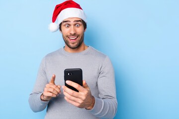 Excited Man in Santa Hat Looking at Smartphone
