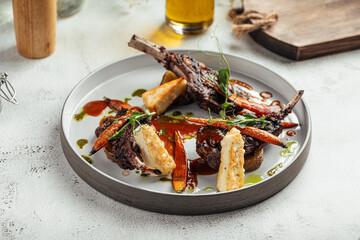 Juicy lamb chops served with roasted carrots, fried cheese and herb sauce