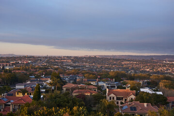 Fototapeta premium Aerial view of Johannesburg city centre at sunrise, South Africa. The skyline is bathed in warm morning light with urban streets, and a vibrant city atmosphere representing modern Africa.