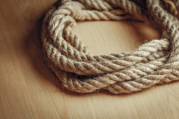 Coiled natural jute rope on wooden surface