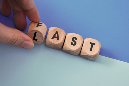 Wooden cubes with the words FAST and LAST â€” a concept of quality against haste