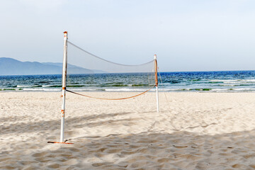 Sandy beach volleyball court by the sea with scenic mountain view