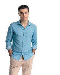 sexy casual guy in blue jeans shirt holding hands in pockets and smiling