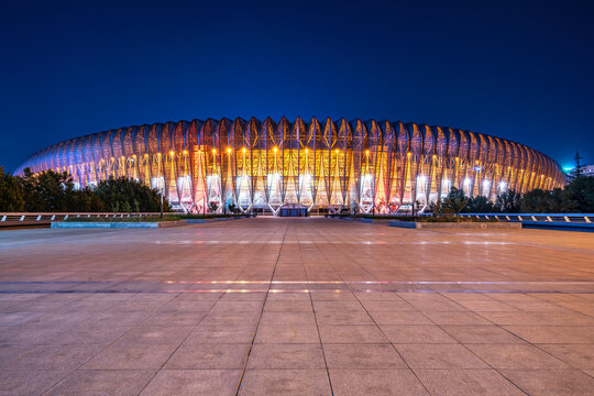 Illuminated modern sports stadium at night with bright lights