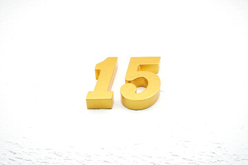 The numbers are made of gold-painted wood, placed on a white background.