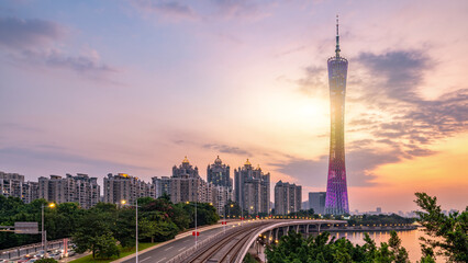 Sunset view of a modern city with a tall landmark tower