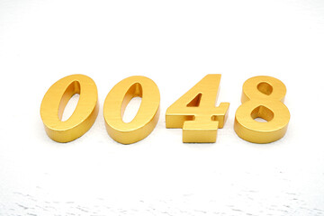 The numbers are made of gold-painted wood, placed on a white background.