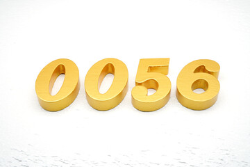 The numbers are made of gold-painted wood, placed on a white background.