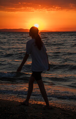 Fototapeta premium woman on the beach at sunset