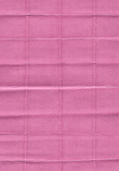 Fototapeta premium scan of pink paper with visible fold lines and creases arranged in a grid pattern. The surface texture highlights the natural imperfections of folded paper, giving it a worn and tactile look.
