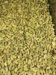 Green cardamom seeds used as spice and flavoring in cooking and drinks. Macro food background.