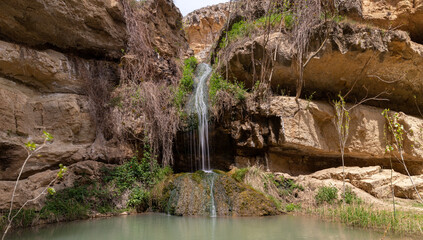 A small waterfall with a lake in the mountains.