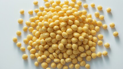 Yellow soybeans scattered on a white surface.