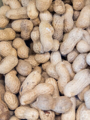 Raw peanuts in shells stacked in bulk. Natural nut and food background.