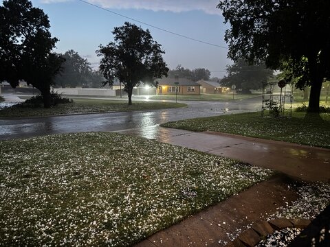 hailstones lay in a front yard alongside flooded streets after a severe summer storm in the midwest - hail and flooding from extreme weather storms