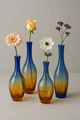 Colorful wildflowers in elegant blue glass vases on white background
