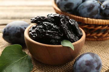 Dried prunes and fresh plums on table, closeup