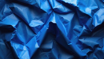 Wrinkled blue paper or fabric texture with folds and creases.