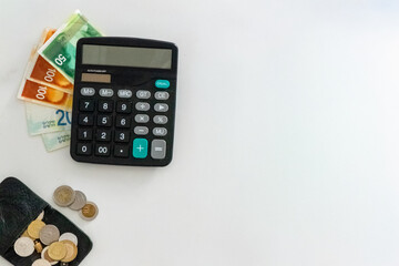 Calculator with Dollar and Shekel Banknotes on Desk