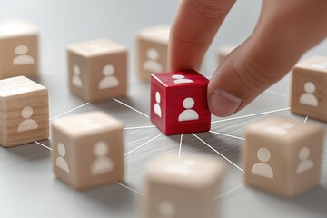 Una mano señala un cubo rojo en medio de una red de cubos con figuras humanas, simbolizando la importancia y conexión.