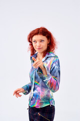 A woman with red hair is depicted against the background of a white canvas, dressed in a bright shirt with a rainbow print.