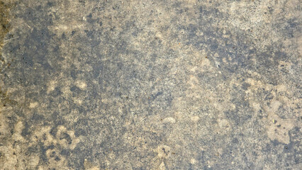 a worn and weathered concrete surface with visible stains, discoloration, and uneven texture. The surface has patches of darker and lighter tones, giving it an aged, mottled appearance. © Leiter1940s
