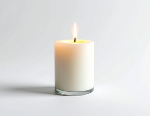 white pillar candle with a steady flame, sitting on a glass base, isolated on a light gray background.