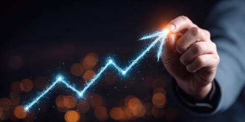 A hand draws a glowing, jagged upward trending line against a dark, blurry background. The line leads to a bright orange flare