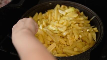 Chef frying potatoes in pan