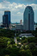 Obraz premium greenery natural park of big city at noon with cloudy sky with spot light from the sun at the walkway of the park
