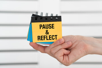 Notes Pause and reflect in a female hand. Stop, think, and assess a situation, experience, or decision before moving forward.