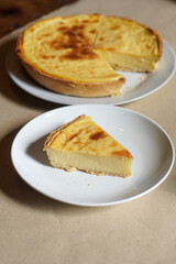 Custard Tart Slice on White Plate with Whole Tart in Background