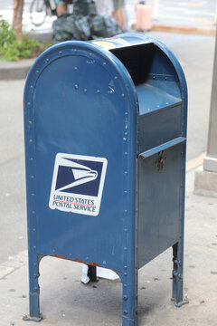 New York, NY, USA - August 24, 2025: blue US Postal Service USPS mailbox on an urban sidewalk