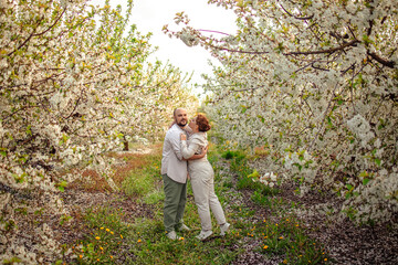 happy couple of adults on a walk in the spring park. family leisure. husband and wife walking in nature