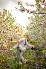 happy couple of adults on a walk in the spring park. family leisure. husband and wife walking in nature