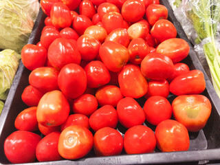 Generous pile of ripe red tomatoes, a fresh and healthy harvest from a local market. Vibrant colors and textures for a food, nutrition, or farm-to-table theme.