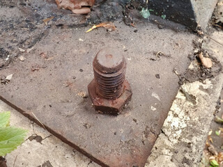 Obraz premium close-up of a rusted bolt and nut on a weathered metal plate, symbolizing decay and the passage of time