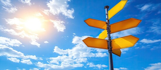 Bright Sun Illuminates Yellow Directional Signpost Against Vivid Blue Sky with Fluffy Clouds
