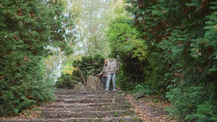 mother holds daughter hand while leading dog down stone staircase winding through lush green garden framed by autumn leaves wearing cozy jackets joyful family moment in serene outdoor pathway - Powered by Adobe