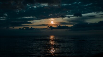 Dramatic sunset over a calm ocean with vibrant orange sun and reflection on the water surface