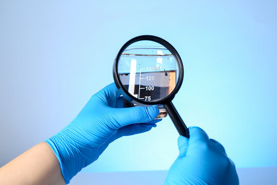 Scientist with magnifying glass and sample of water on light blue background, closeup - Powered by Adobe