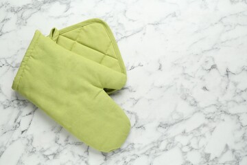 Oven glove and potholder on white marble table, flat lay. Space for text