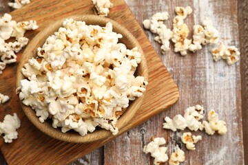 Tasty popcorn on wooden table, flat lay