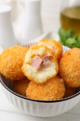 Delicious fried croquette balls in bowl on table, closeup